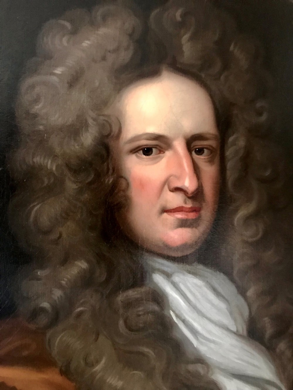 A seventeenth-century oil portrait depicting a gentleman with a large curling periwig and white cravat set inside a feigned oval within a gilded frame. View III