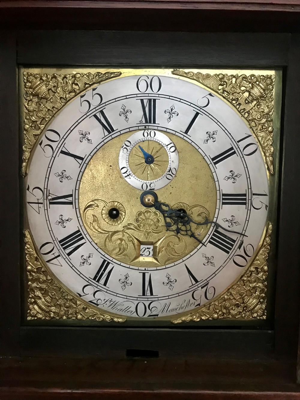 An 18th-century dark oak longcase clock featuring a square brass dial, moulded hood, and a shaped door on the main body. View II