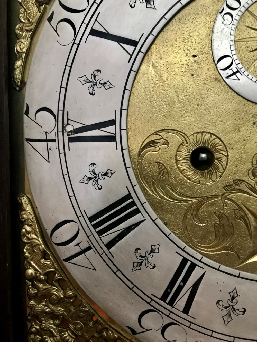 An 18th-century dark oak longcase clock featuring a square brass dial, moulded hood, and a shaped door on the main body. View III