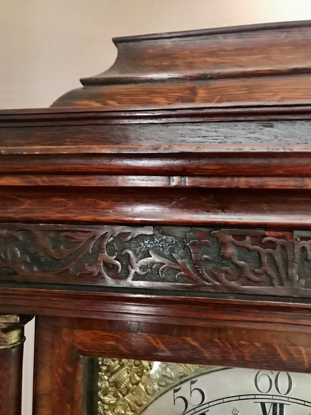 An 18th-century dark oak longcase clock featuring a square brass dial, moulded hood, and a shaped door on the main body. View VII