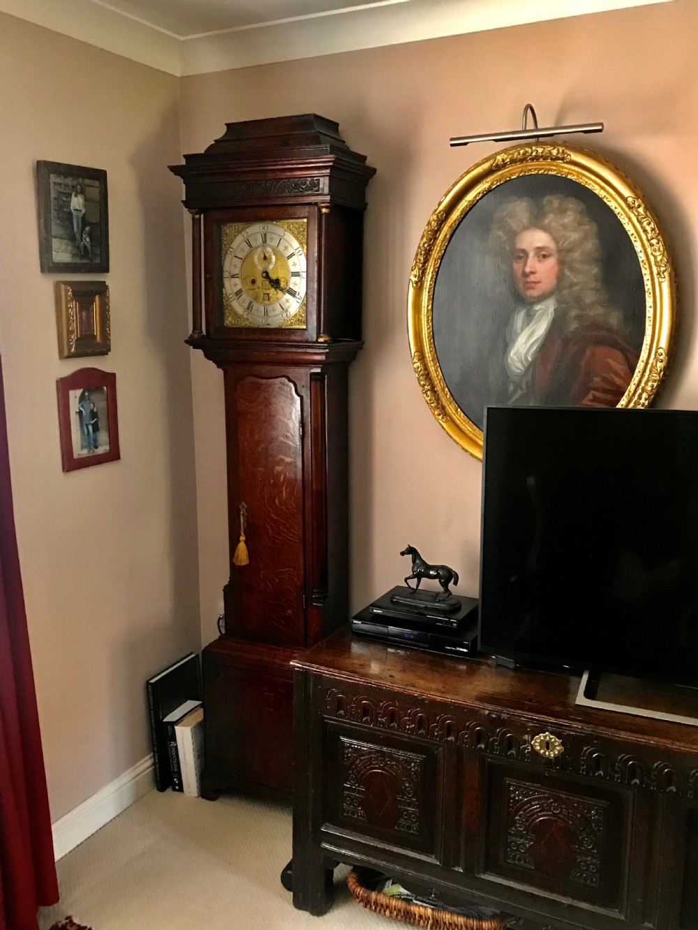 An 18th-century dark oak longcase clock featuring a square brass dial, moulded hood, and a shaped door on the main body. View IX