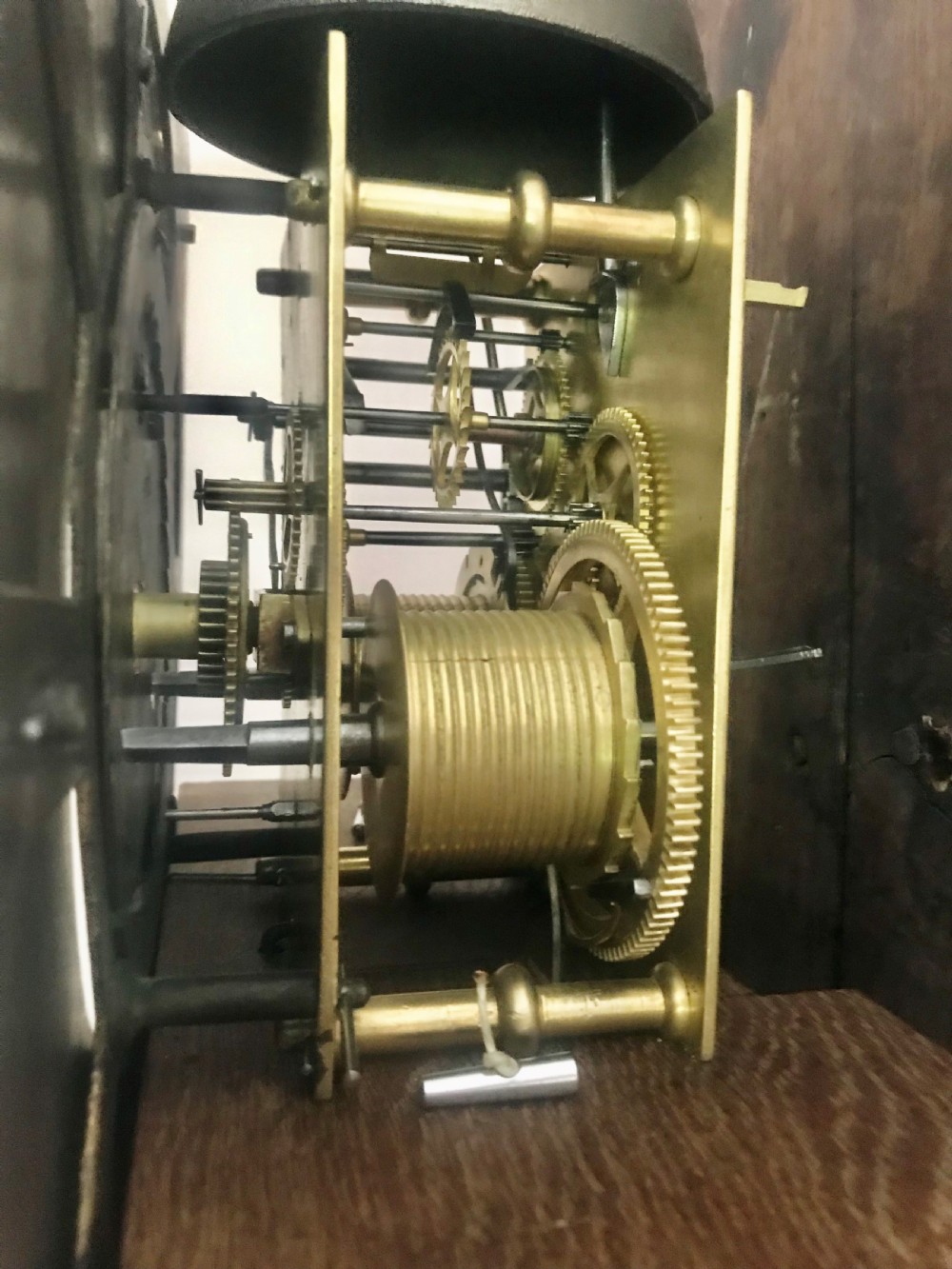 An 18th-century dark oak longcase clock featuring a square brass dial, moulded hood, and a shaped door on the main body. View X