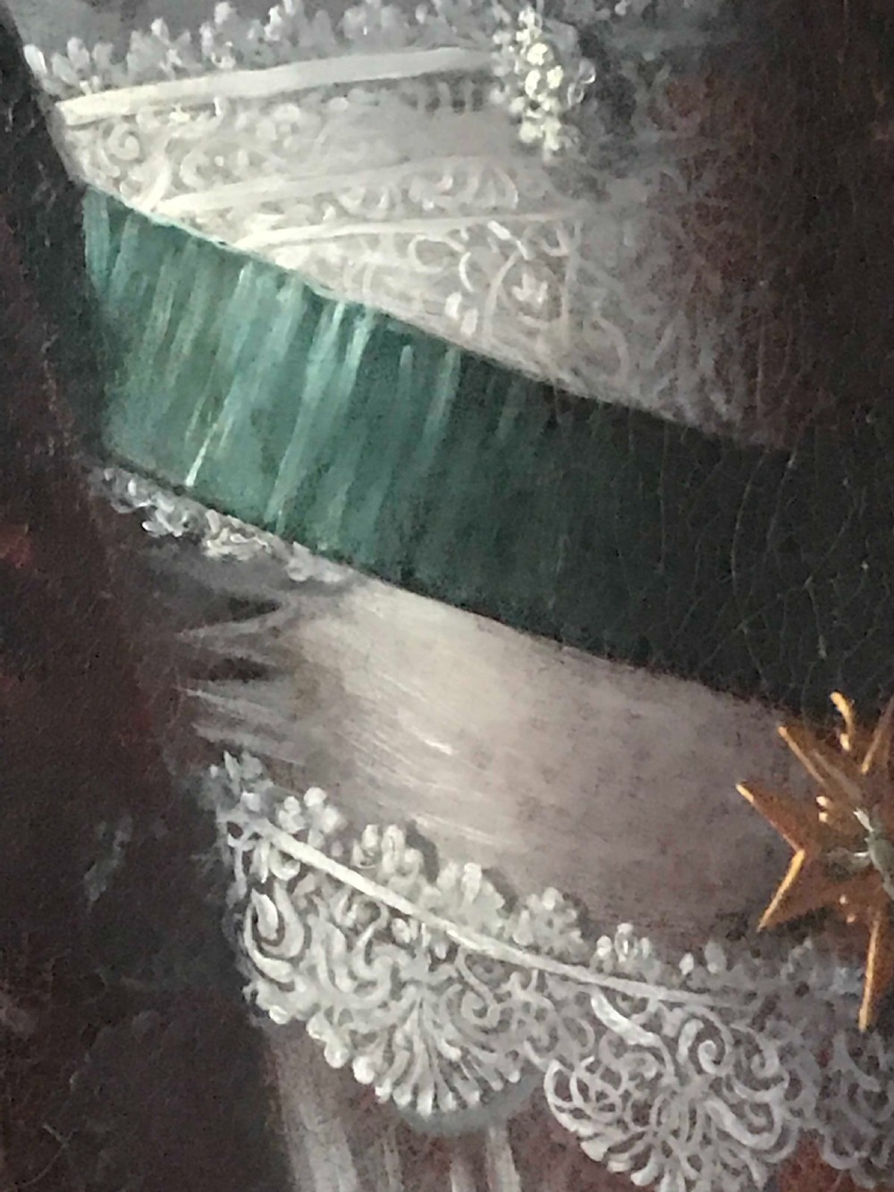 A seventeenth-century Baroque oil painting on canvas depicting a young child wearing a crimson feathered hat and ornate lace attire within a gilded wood frame. View VI