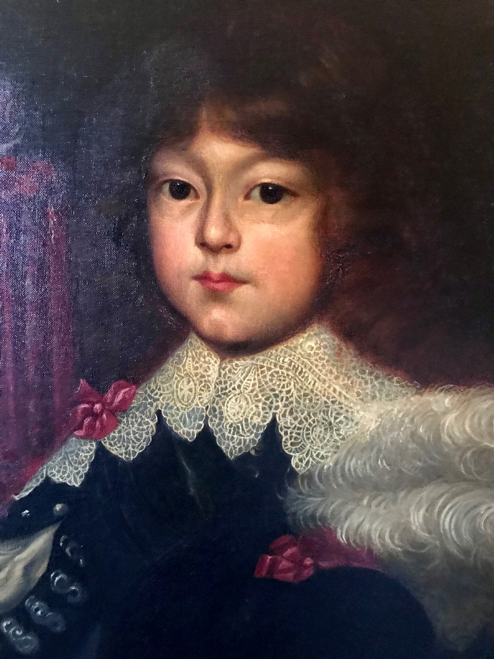 A framed oil painting depicting a child in dark 17th-century attire with a white lace collar holding a feathered hat. View II