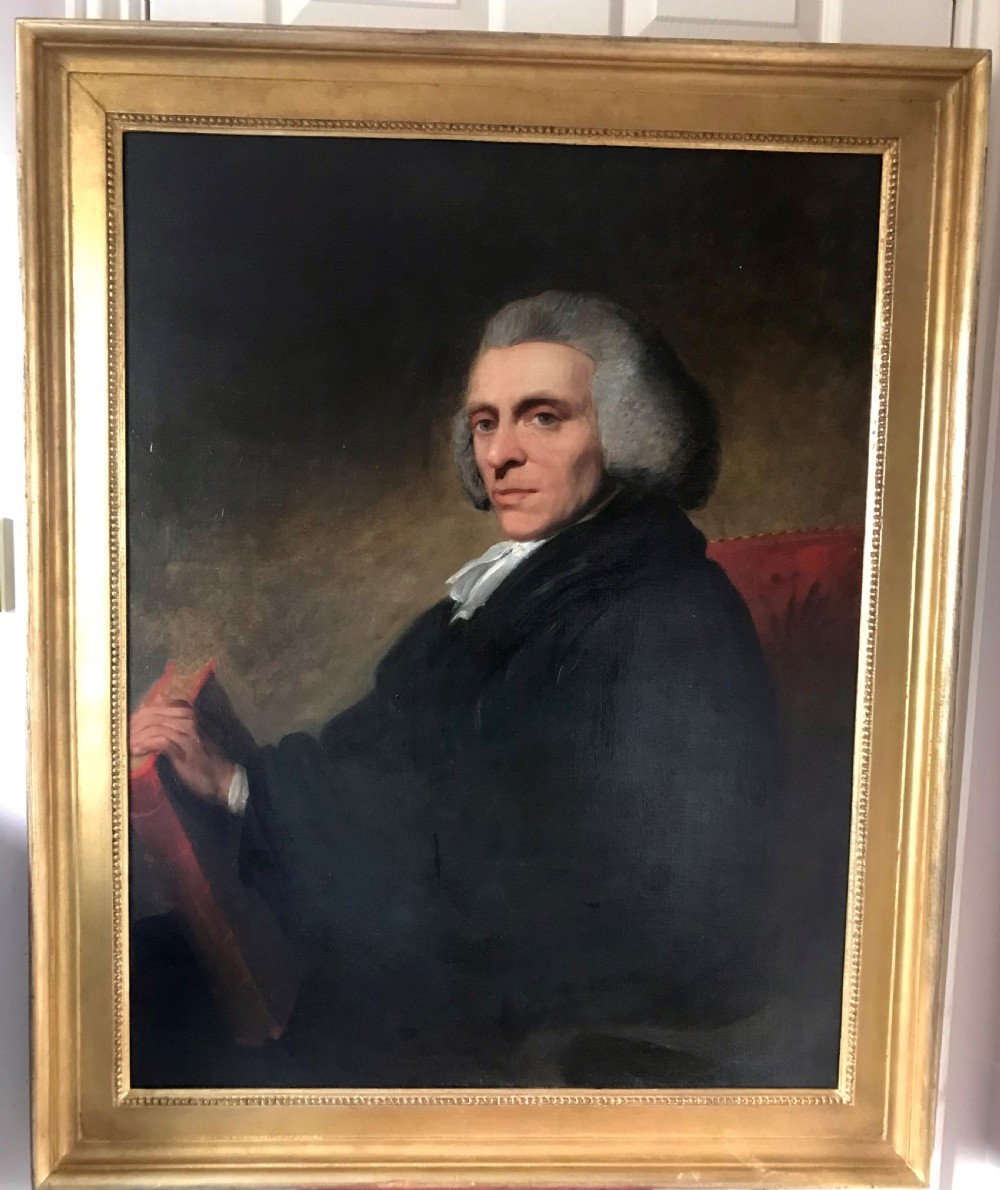 A late 18th-century oil portrait of a seated clergyman wearing a powdered wig and dark coat, set within a moulded gilded frame.