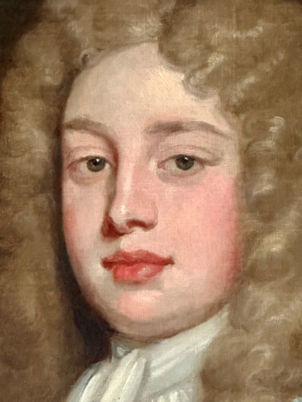 An 18th-century oil portrait painting depicting a gentleman with a long wig, white cravat, and teal blue coat, set within a carved gold frame. View III