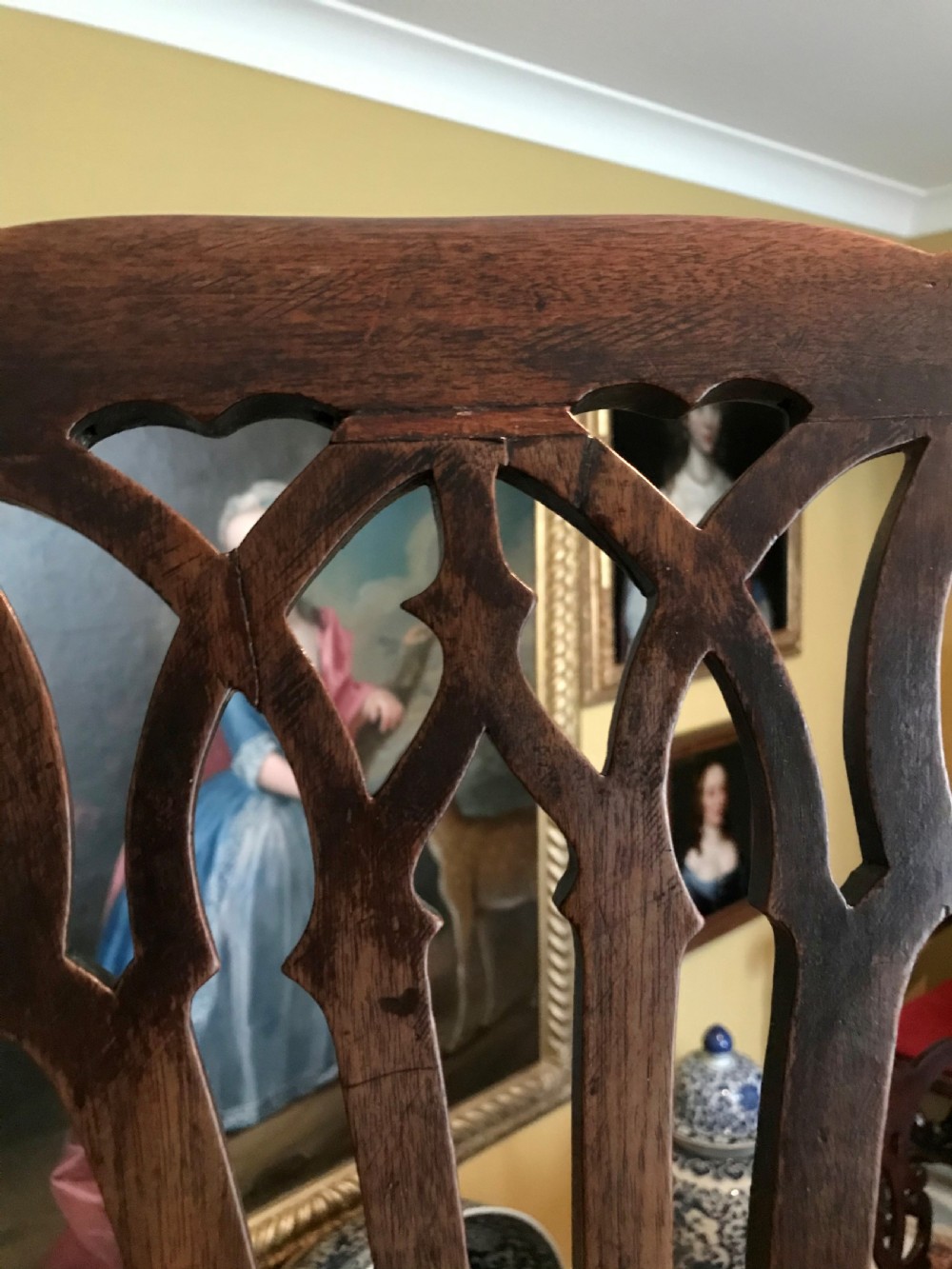 An 18th-century country Chippendale side chair featuring a carved pierced back splat, a square seat upholstered in red fabric, and straight legs joined by stretchers. View V