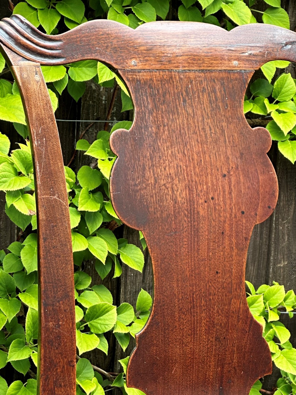 A set of three mid-18th-century Georgian mahogany side chairs featuring vasiform back splats, carved top rails, and red patterned drop-in seats. View II