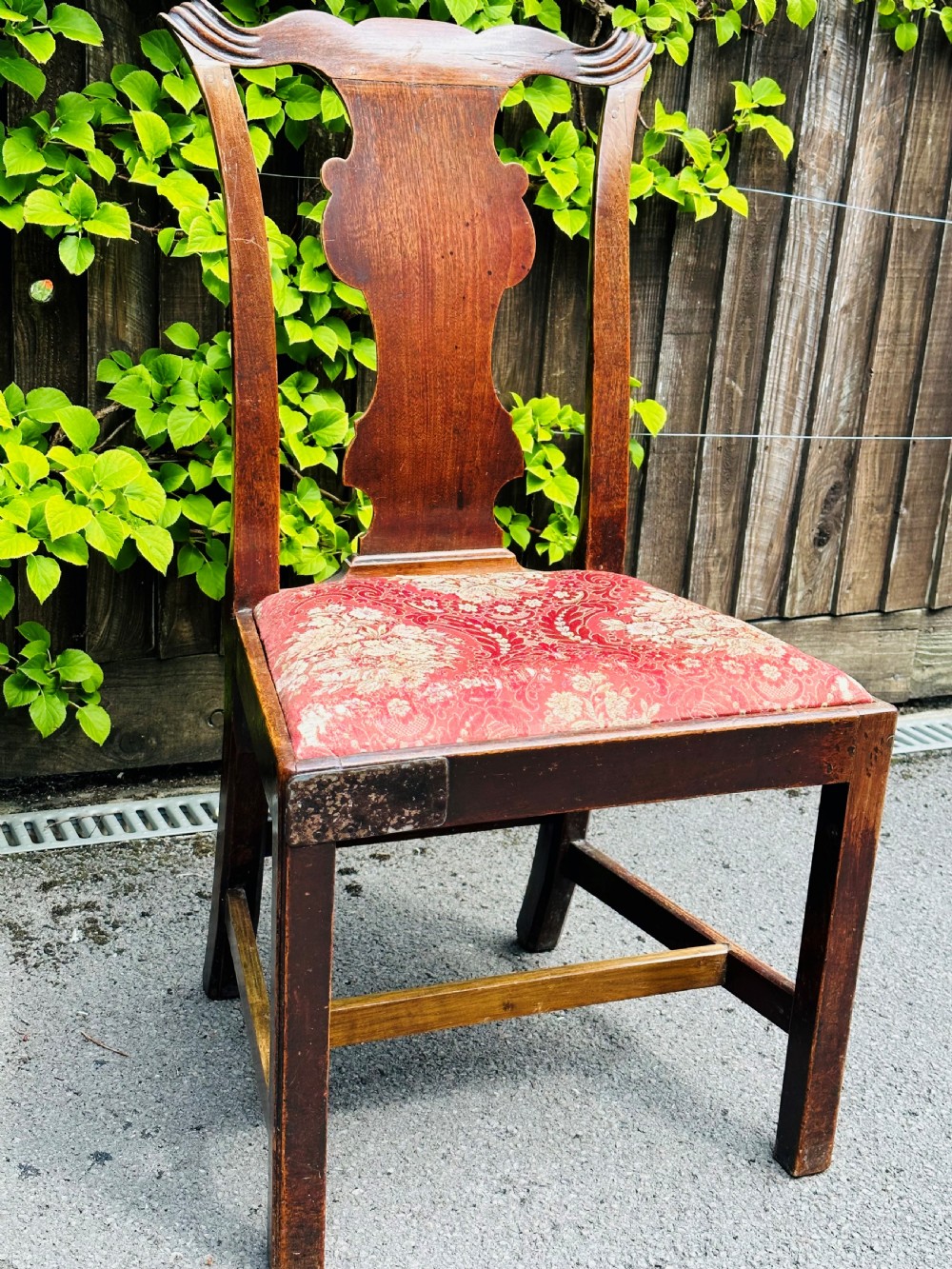A set of three mid-18th-century Georgian mahogany side chairs featuring vasiform back splats, carved top rails, and red patterned drop-in seats. View III