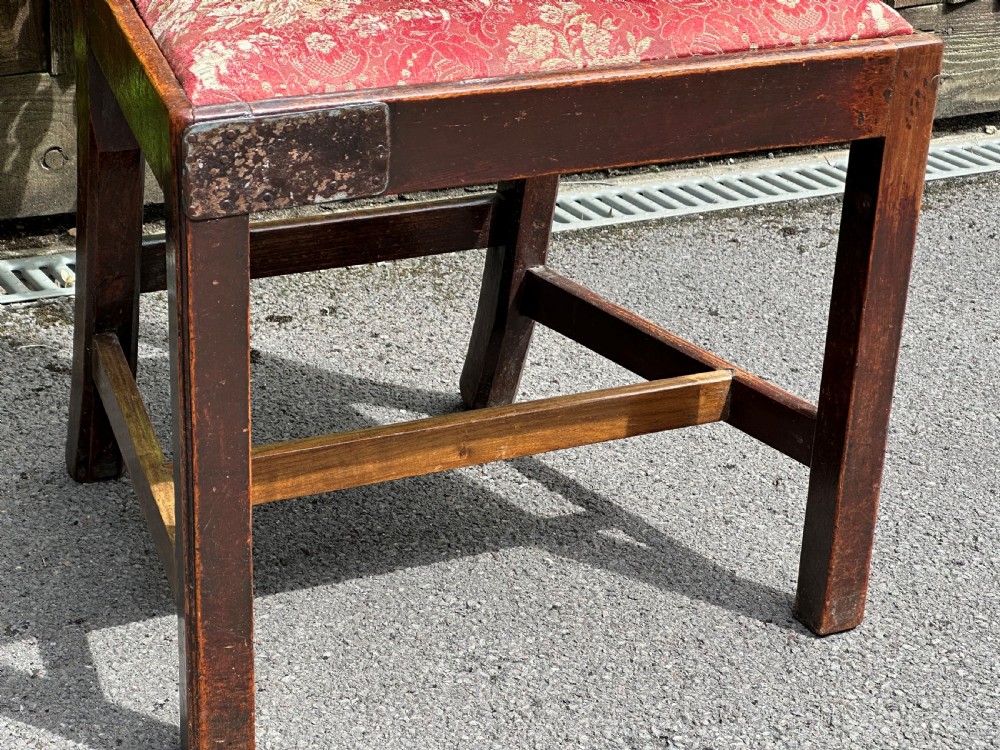A set of three mid-18th-century Georgian mahogany side chairs featuring vasiform back splats, carved top rails, and red patterned drop-in seats. View IV