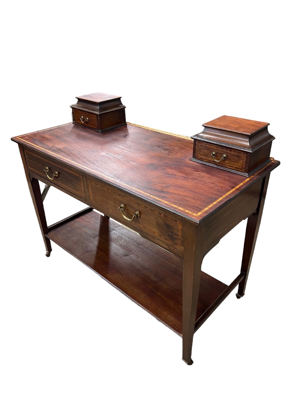 An Edwardian mahogany dressing table featuring satinwood crossbanding, two frieze drawers, two raised corner drawers, a lower shelf, and brass castors. View II