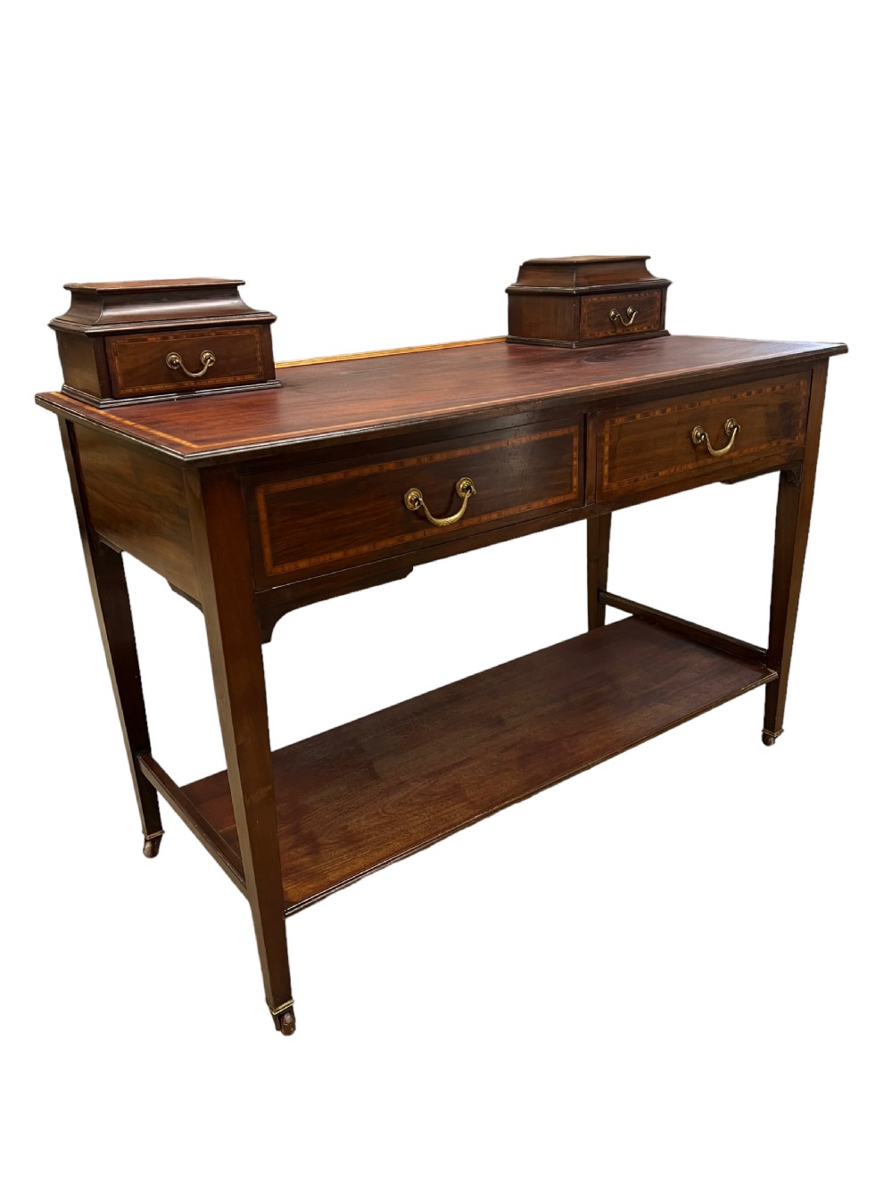An Edwardian mahogany dressing table featuring satinwood crossbanding, two frieze drawers, two raised corner drawers, a lower shelf, and brass castors. View III