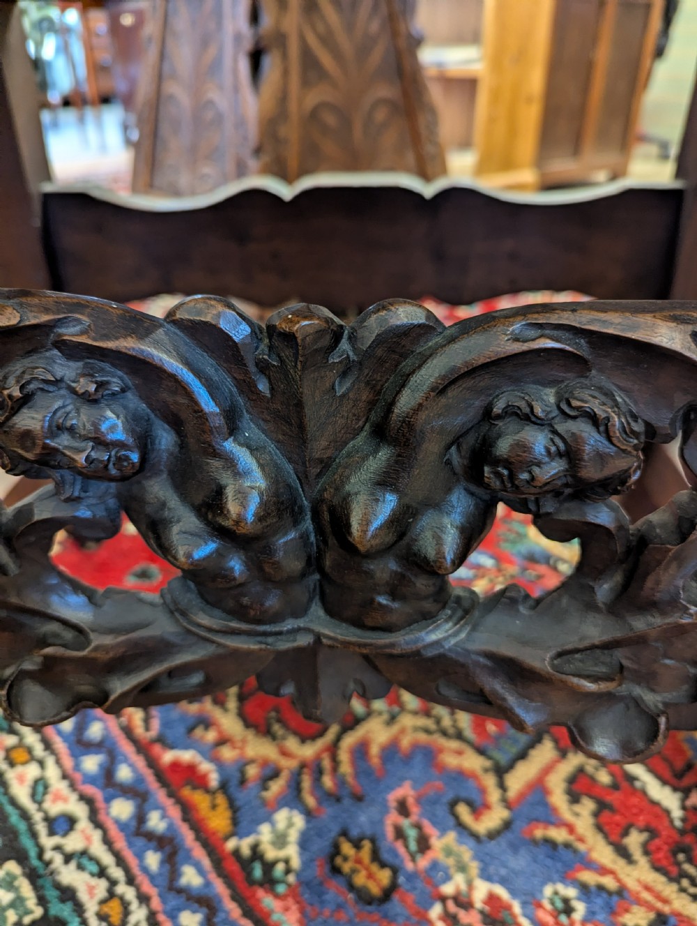 An 18th-century European walnut throne chair featuring high-backed studded leather upholstery, carved armrests, finials, and an ornate lower stretcher. View II