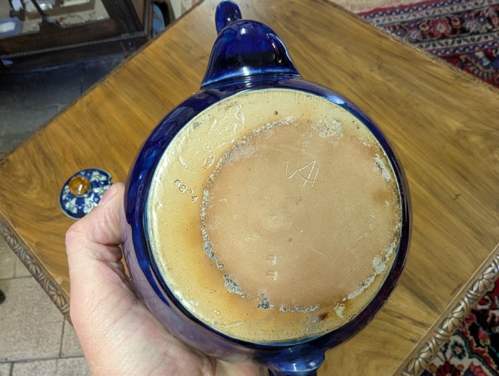 An Art Nouveau Royal Doulton stoneware teapot featuring a cobalt blue base, an olive green shoulder with raised relief patterns, and a fitted lid. View II