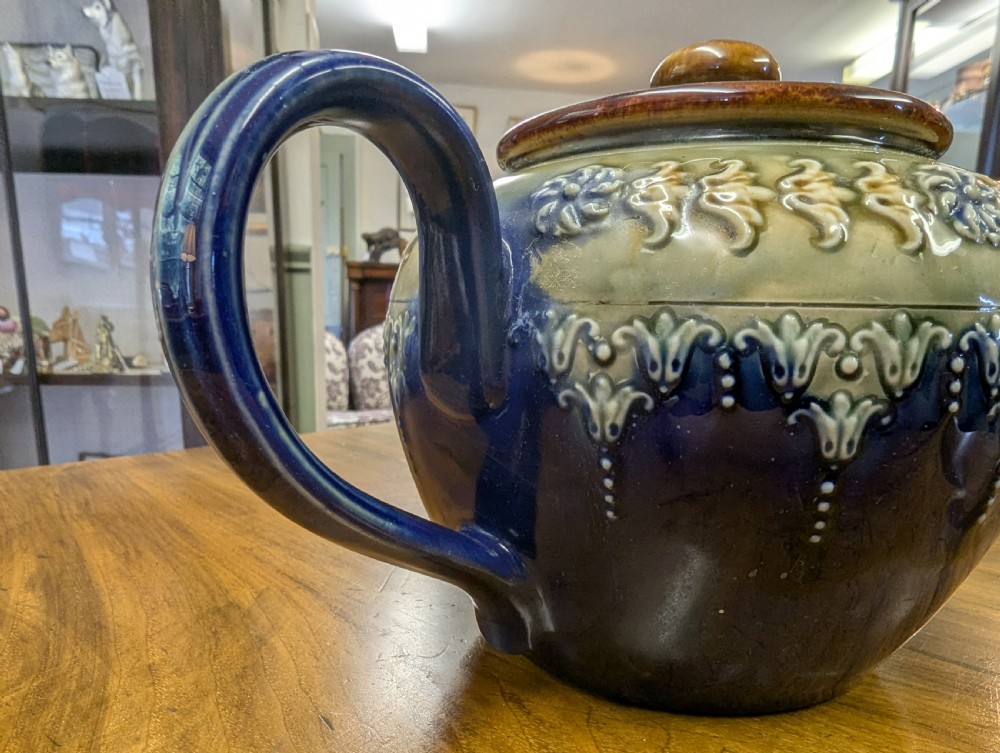 An Art Nouveau Royal Doulton stoneware teapot featuring a cobalt blue base, an olive green shoulder with raised relief patterns, and a fitted lid. View VII