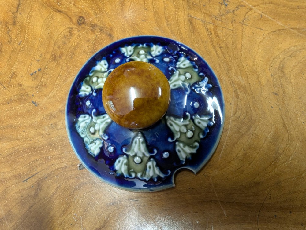 An Art Nouveau Royal Doulton stoneware teapot featuring a cobalt blue base, an olive green shoulder with raised relief patterns, and a fitted lid. View VIII