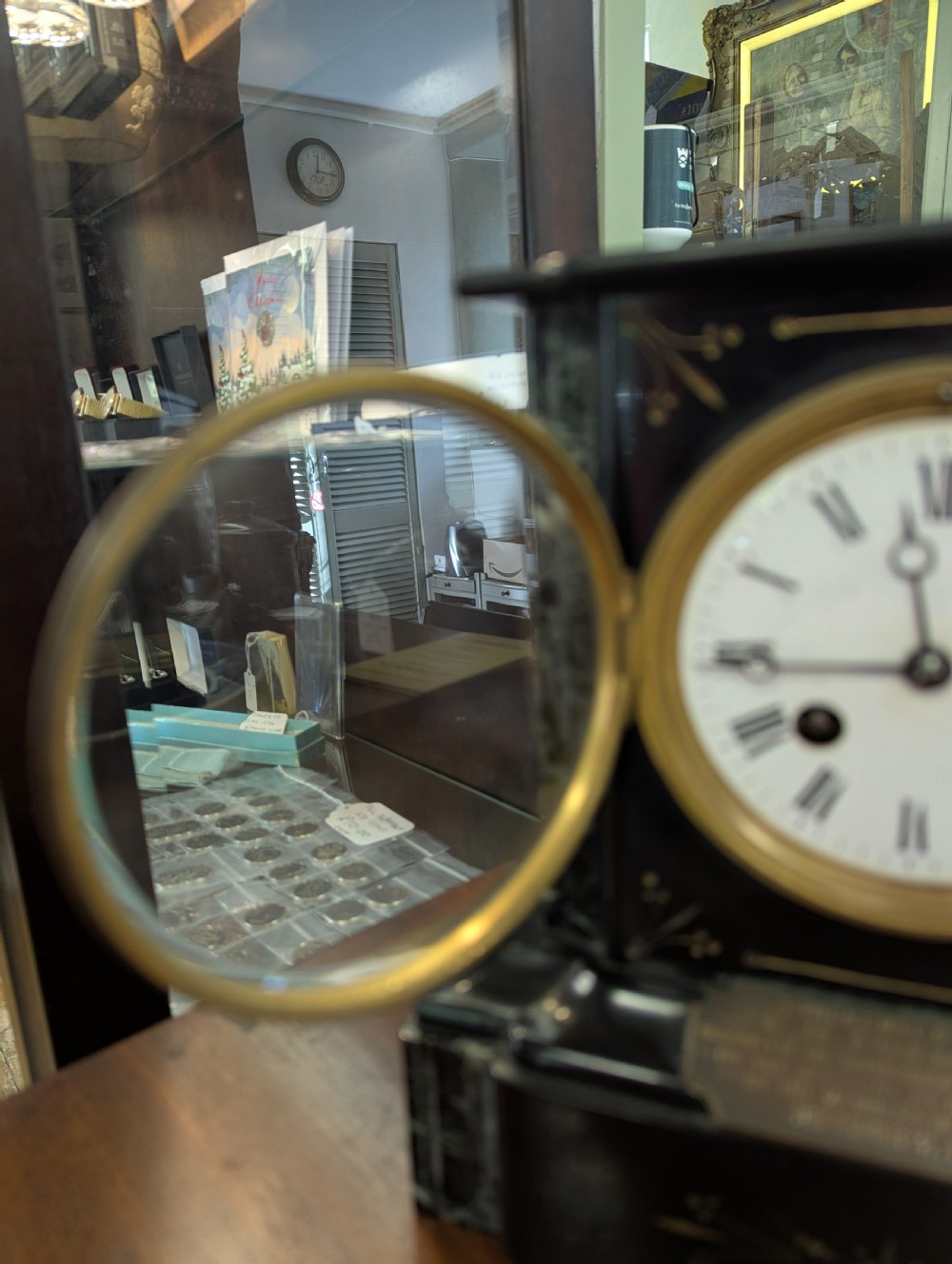 A Victorian black marble and slate mantel clock featuring incised gilded floral patterns, a white enamel dial with Roman numerals, and a brass presentation plaque. View V