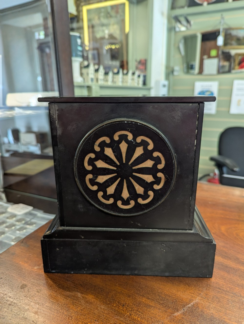 A Victorian black marble and slate mantel clock featuring incised gilded floral patterns, a white enamel dial with Roman numerals, and a brass presentation plaque. View X