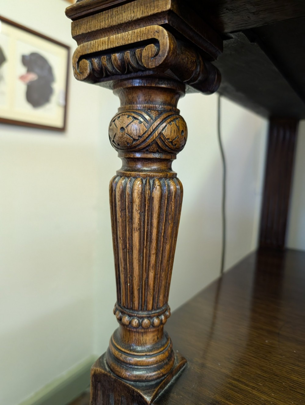 A late Victorian carved oak buffet featuring two top drawers with brass drop handles, an open tier, and a lower double-door cabinet decorated with detailed carved foliage. View VIII