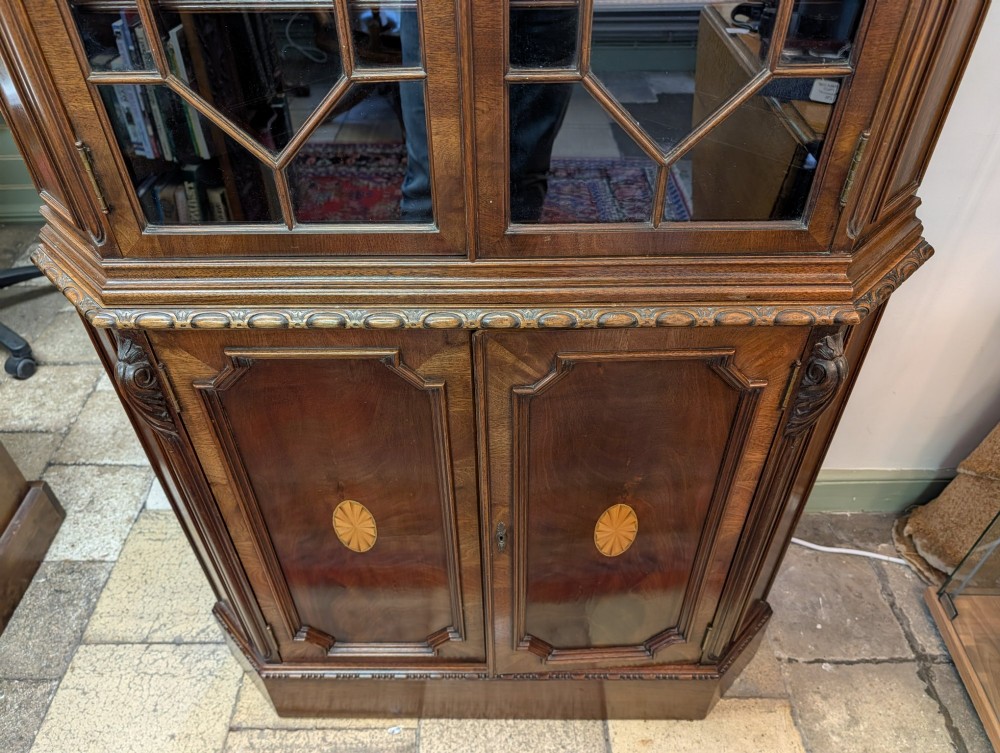 An Edwardian mahogany corner display cabinet featuring a swan-neck pediment, astragal glazed top doors, and lower inlaid timber panelled doors. View III