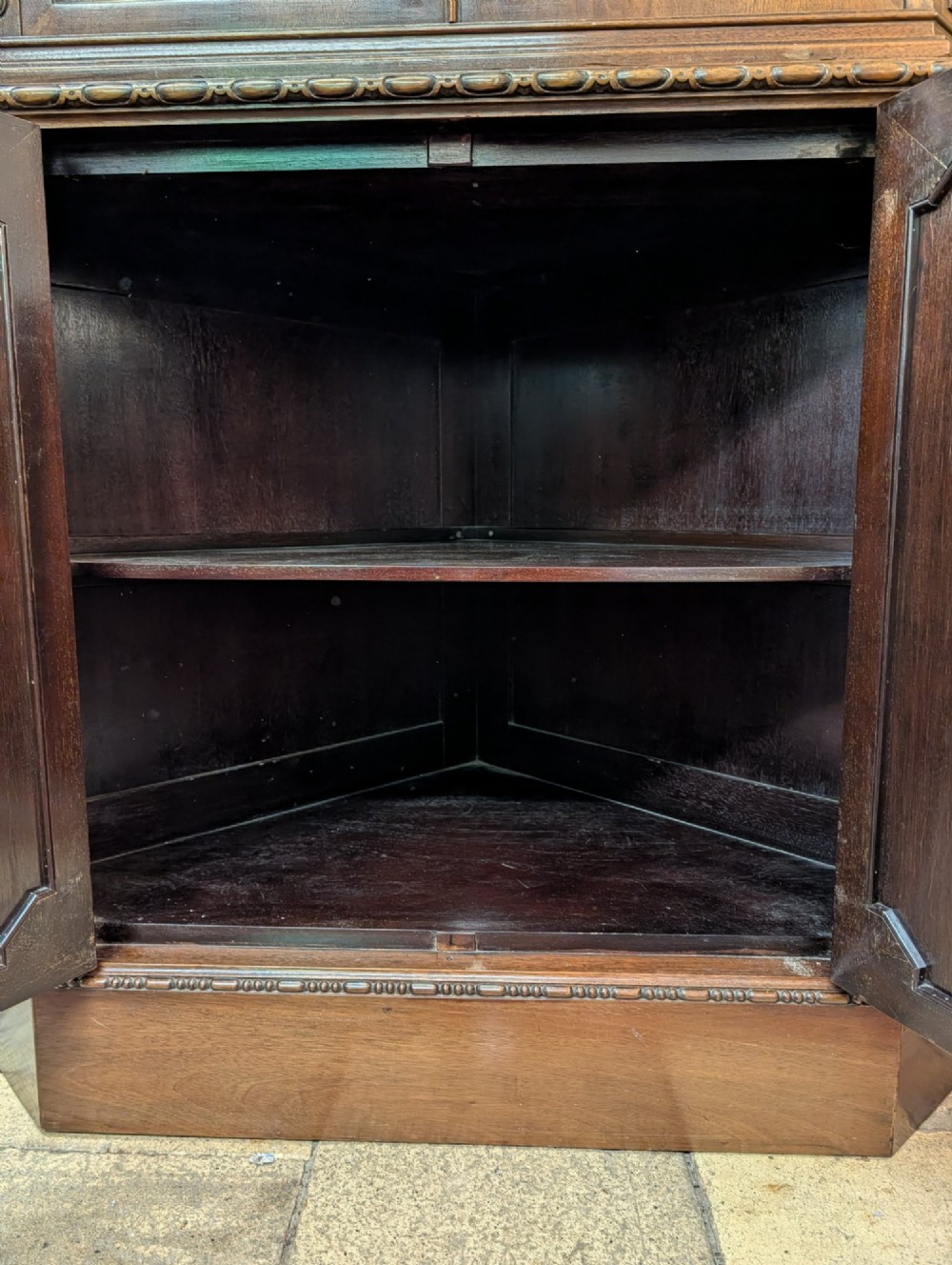 An Edwardian mahogany corner display cabinet featuring a swan-neck pediment, astragal glazed top doors, and lower inlaid timber panelled doors. View VI