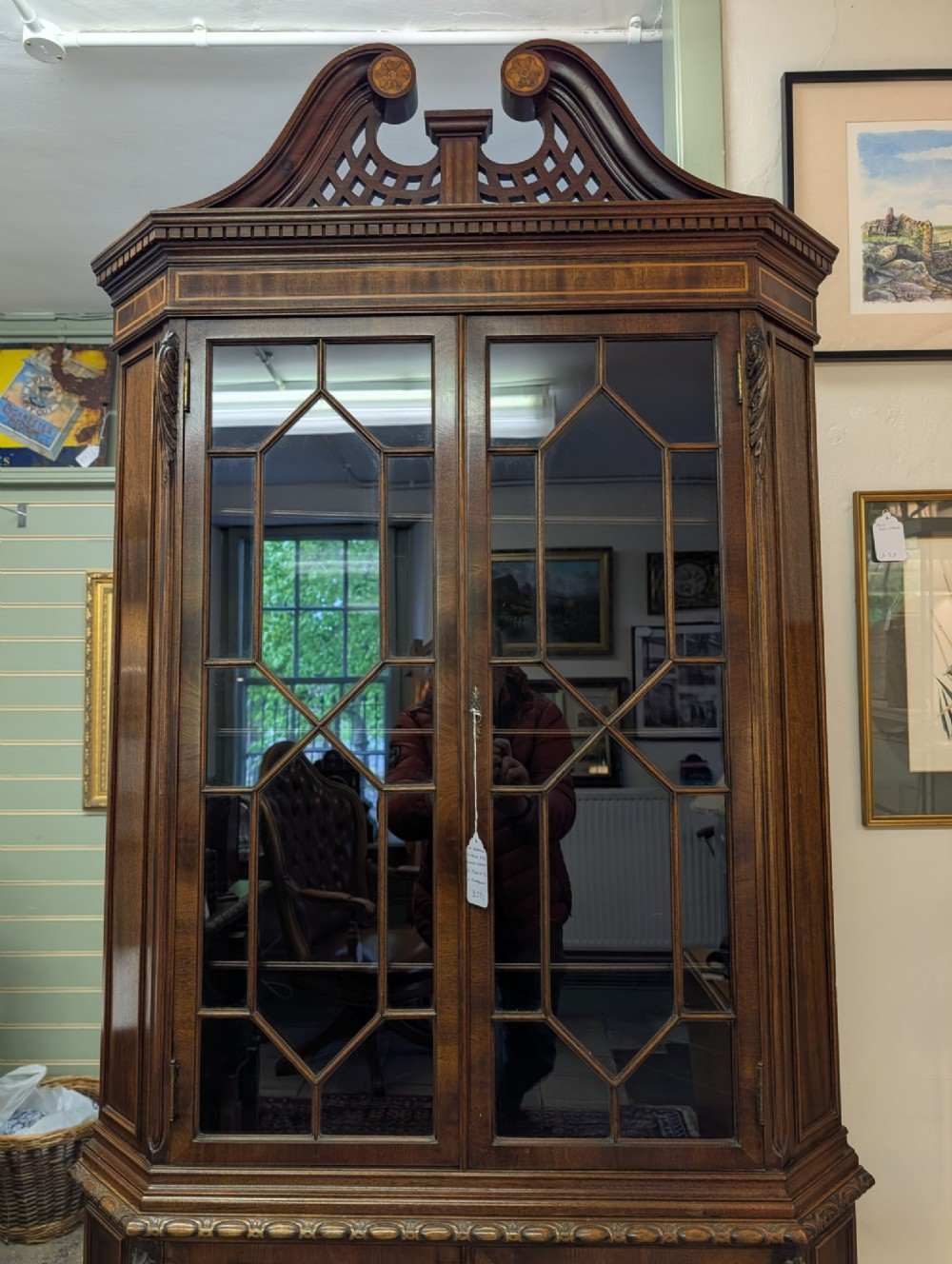 An Edwardian mahogany corner display cabinet featuring a swan-neck pediment, astragal glazed top doors, and lower inlaid timber panelled doors. View VIII