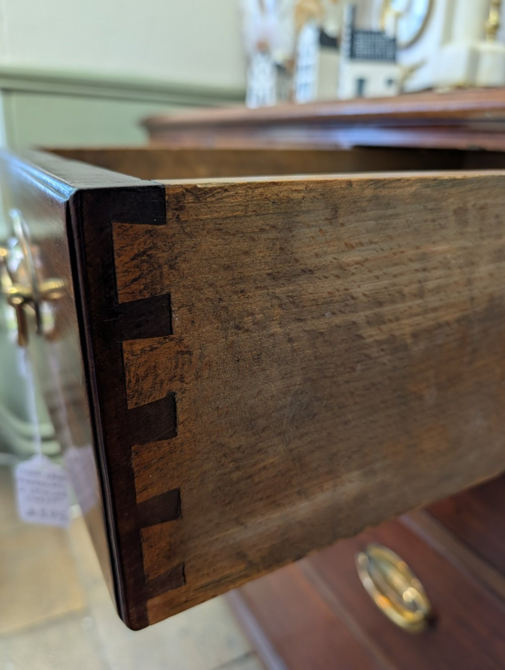 A Georgian mahogany chest of drawers featuring three small upper drawers over three long graduated drawers with brass handles. View IV