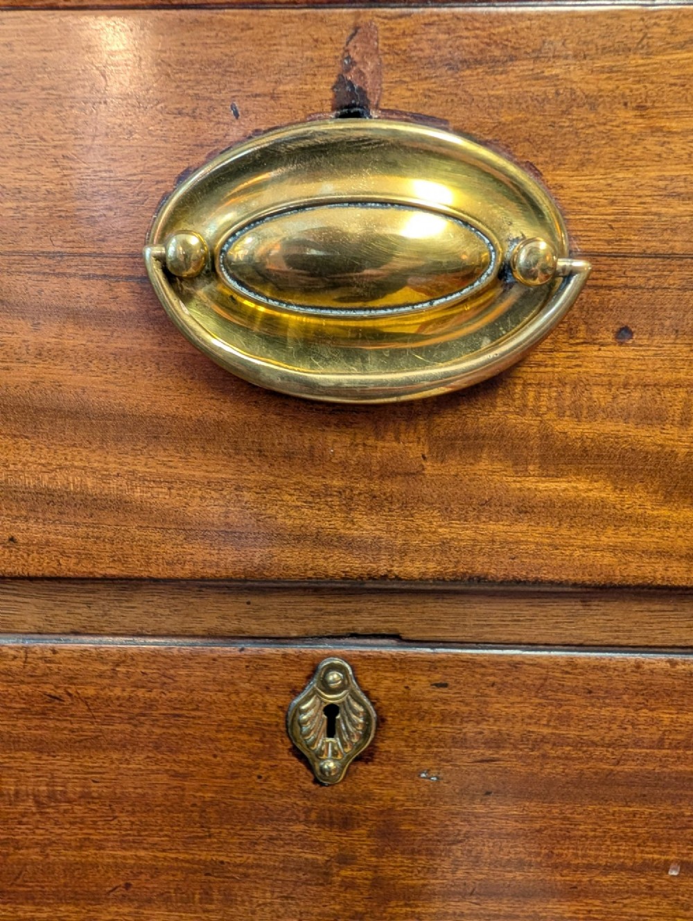 A Georgian mahogany chest of drawers featuring three small upper drawers over three long graduated drawers with brass handles. View VI