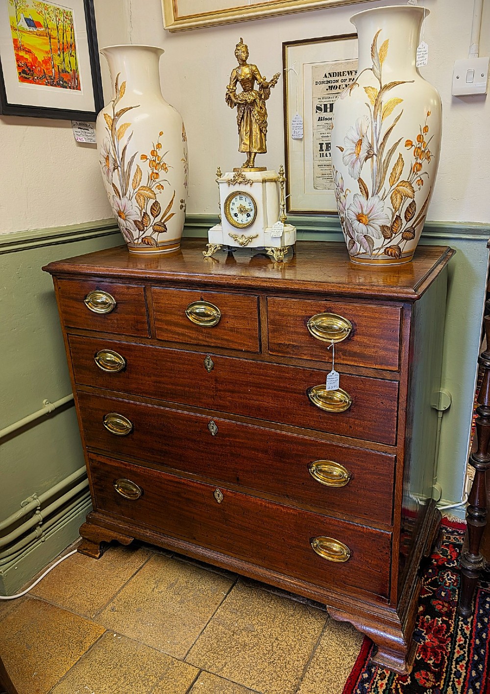 A Georgian mahogany chest of drawers featuring three small upper drawers over three long graduated drawers with brass handles.