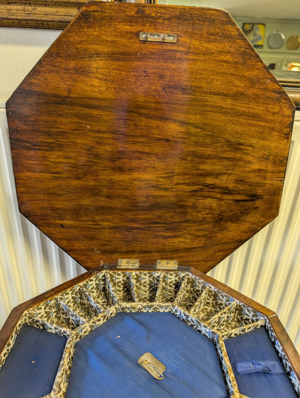 A Victorian octagonal walnut games table featuring an inlaid chessboard lid above a tapering trumpet pedestal on carved tripod legs. View II