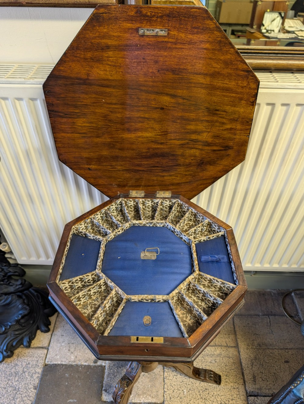 A Victorian octagonal walnut games table featuring an inlaid chessboard lid above a tapering trumpet pedestal on carved tripod legs. View V