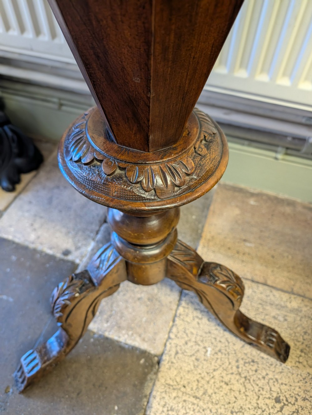 A Victorian octagonal walnut games table featuring an inlaid chessboard lid above a tapering trumpet pedestal on carved tripod legs. View VI