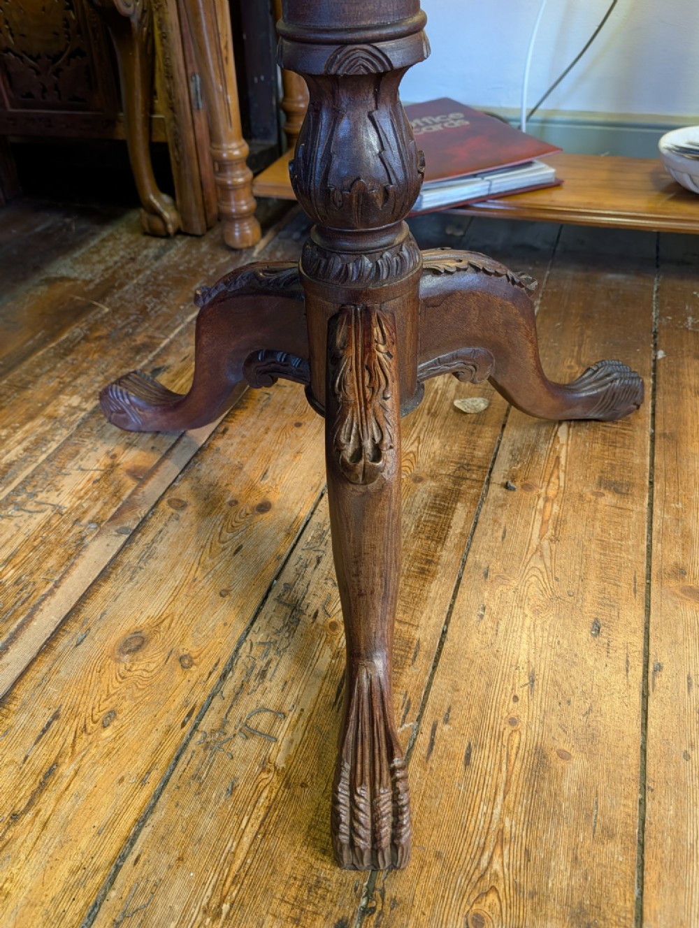 A top-down view of a 19th-century mahogany tilt-top table featuring a carved scalloped edge with shell motifs on a central turned pedestal base. View VI