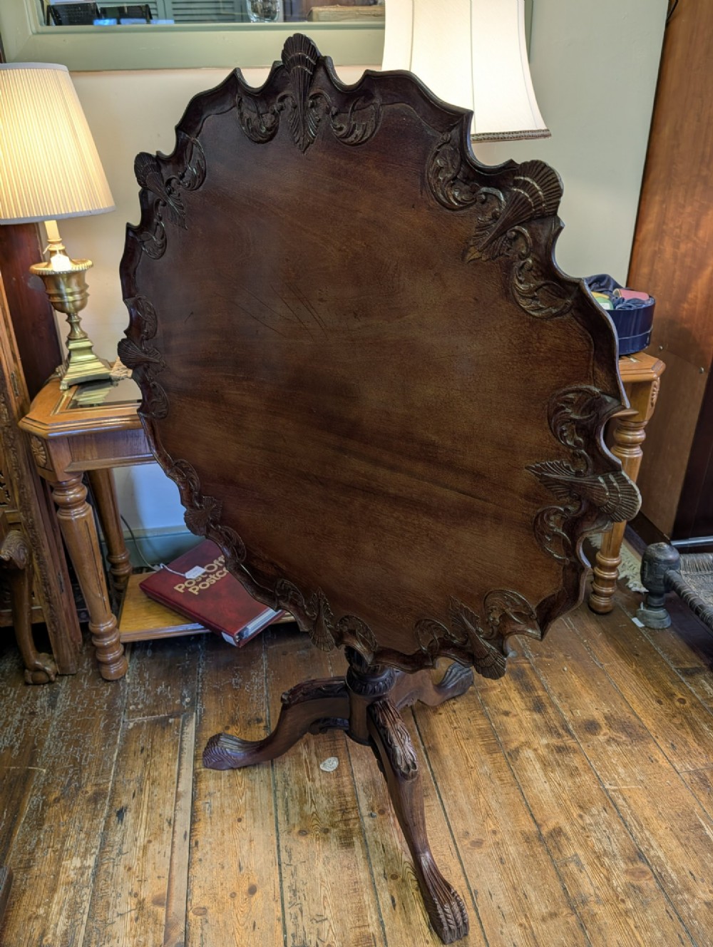 A top-down view of a 19th-century mahogany tilt-top table featuring a carved scalloped edge with shell motifs on a central turned pedestal base. View VIII