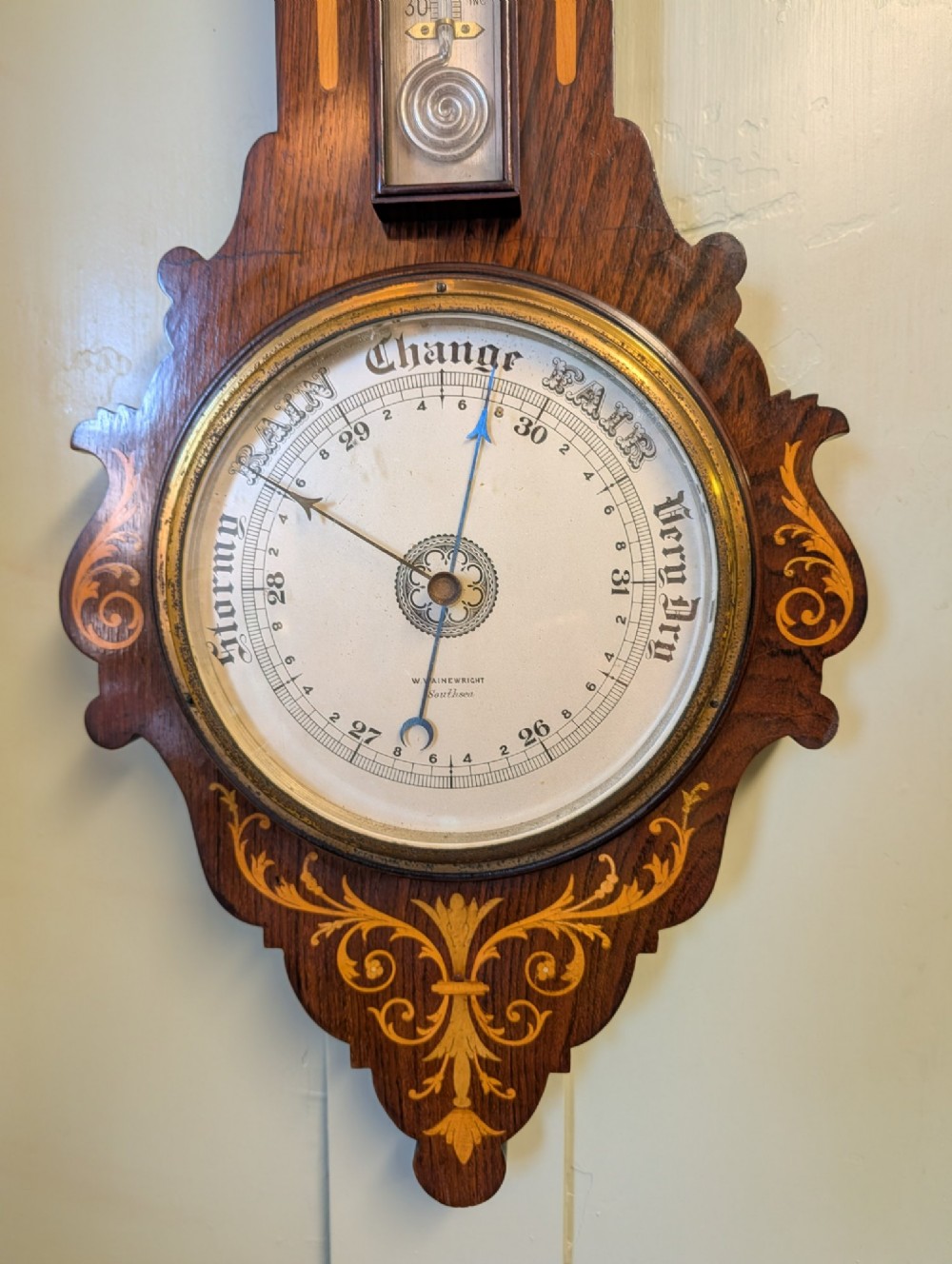 An Edwardian wall-mounted rosewood barometer featuring floral marquetry inlay, a top-mounted glass thermometer, and a circular brass-rimmed pressure dial. View II