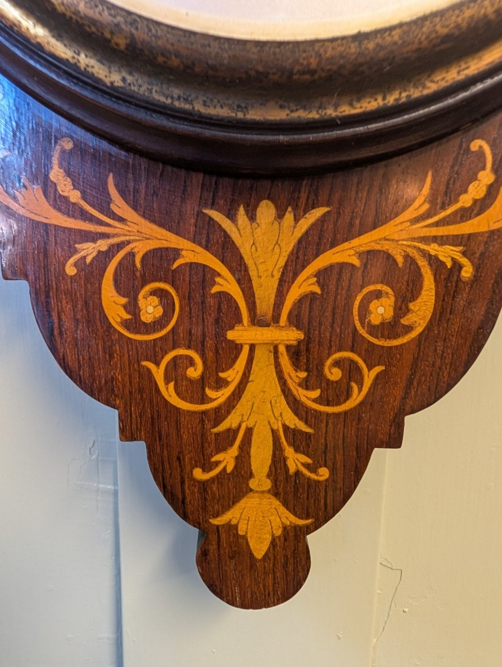 An Edwardian wall-mounted rosewood barometer featuring floral marquetry inlay, a top-mounted glass thermometer, and a circular brass-rimmed pressure dial. View VII