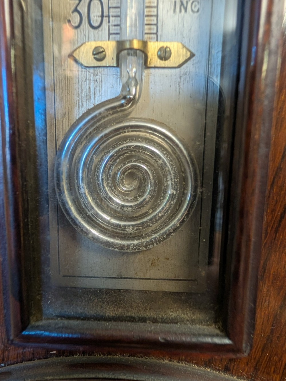 An Edwardian wall-mounted rosewood barometer featuring floral marquetry inlay, a top-mounted glass thermometer, and a circular brass-rimmed pressure dial. View X