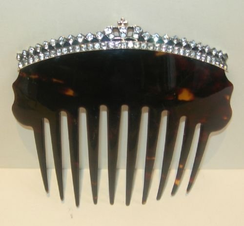 fig 1. An antique dark brown tortoiseshell hair comb featuring an arched top encrusted with clear paste stones forming a crown-shaped crest.