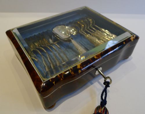 fig 1. A glazed Dutch tortoiseshell presentation box with a key, fitted with a set of silver spoons on blue velvet.