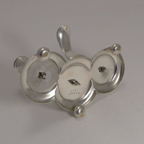 fig 1. A silver-plated novelty table lighter featuring three brick-patterned cylindrical towers mounted on a moulded tri-form base with small ball feet.