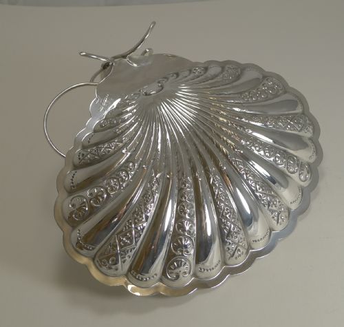 fig 1. A silver-plated strawberry set featuring a scalloped shell tray with two attached fluted bowls and a central arched handle.