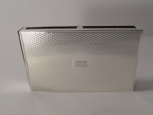 fig 1. A rectangular sterling silver box with a fine engine-turned geometric pattern and a central engraved monogram.