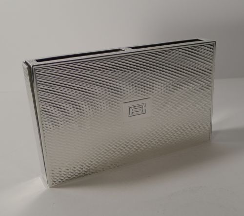fig 2. A rectangular sterling silver box with a fine engine-turned geometric pattern and a central engraved monogram.