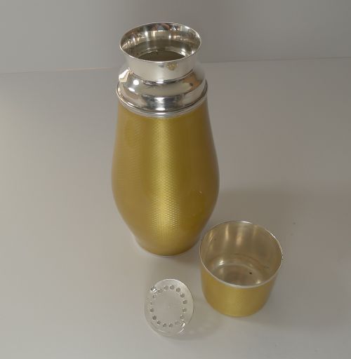 fig 7. A yellow guilloche enamel and sterling silver cocktail shaker with engine-turned geometric detailing.