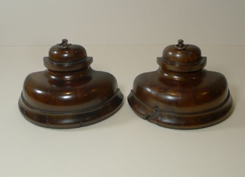 fig 1. A pair of turned dark yew wood bookends featuring stepped moulded bases, domed tops, and brass ring handles.