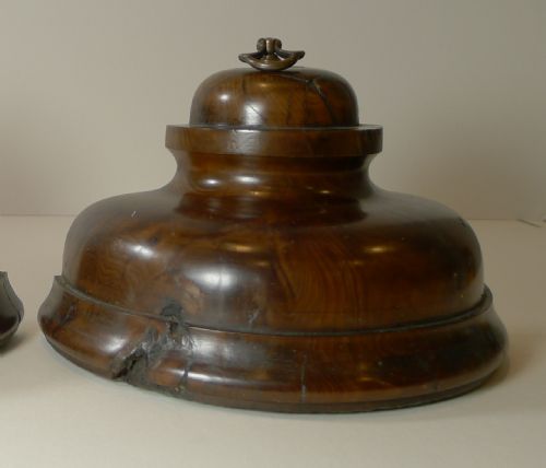 fig 2. A pair of turned dark yew wood bookends featuring stepped moulded bases, domed tops, and brass ring handles.