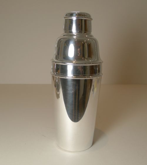 fig 1. A polished silver-plated three-piece Art Deco cocktail shaker featuring stepped rims and a tapered body.