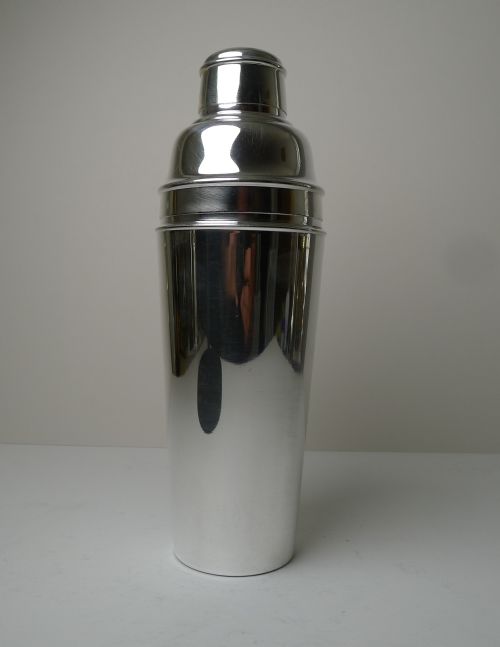 fig 1. A polished silver-plated Art Deco cocktail shaker featuring a tapered cylindrical body, stepped cap, and smooth reflective finish.