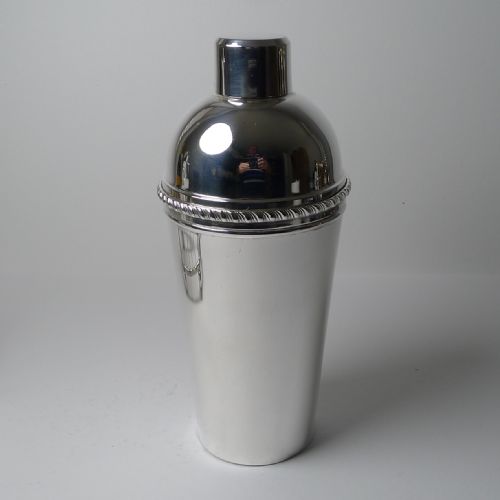 fig 1. A silver-plated three-piece cocktail shaker with a high-shine polished finish and an integrated citrus reamer built into the lid assembly.