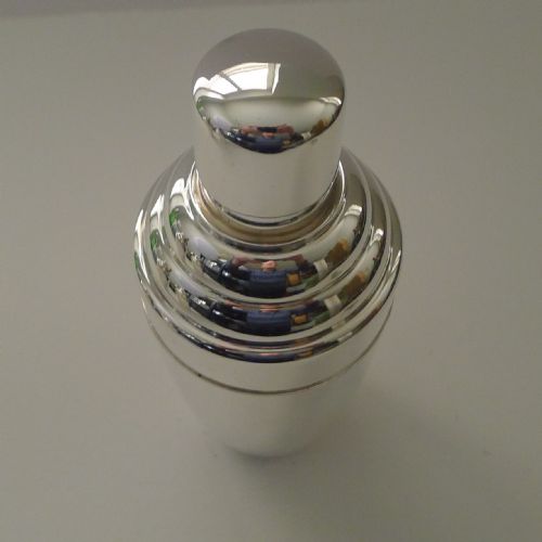 fig 1. A silver-plated Art Deco cocktail shaker featuring a tapered body, stepped shoulder detailing, and a smooth domed top cap.